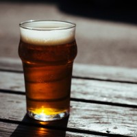 Beer on a table outside in the sun.