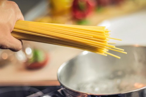 Hand holding some dry pasta